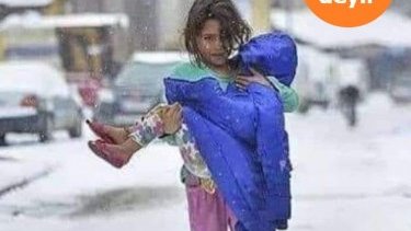 Bacısını gödəkçəsinə bükmüş azyaşlı qızın fotosu